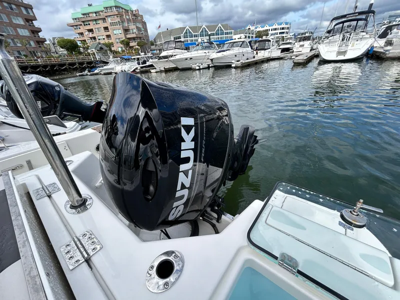Slide: The Image of 2024 Sailfish 226 DC with Suzuki outboard motor docked in a marina. - 18