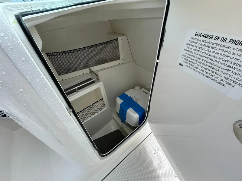 Slide: The Image of Storage compartment on 2024 Sailfish 226 DC boat with safety notice and equipment. - 19