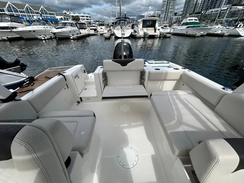 Slide: The Image of 2024 Sailfish 226 DC boat interior at marina, showcasing spacious seating and modern design. - 21