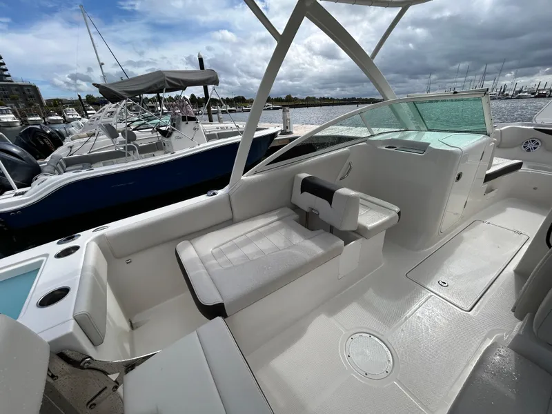 Slide: The Image of 2024 Sailfish 226 DC boat interior at marina, featuring seating and open deck. - 22