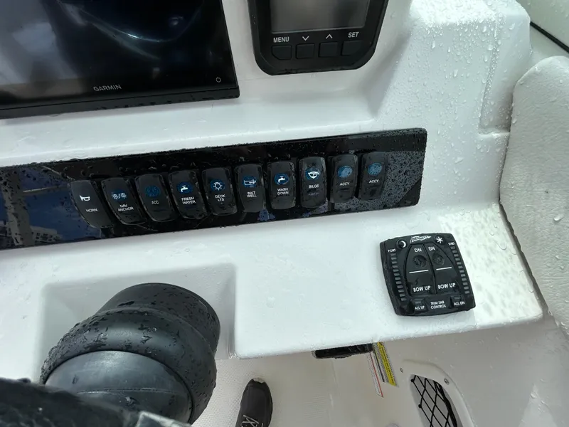 Slide: The Image of 2024 Sailfish 226 DC boat dashboard with control panel and steering wheel. - 26