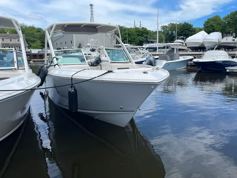 Slide: The Image of 2024 Sailfish 226 DC boat docked in a marina, surrounded by other vessels. - 3