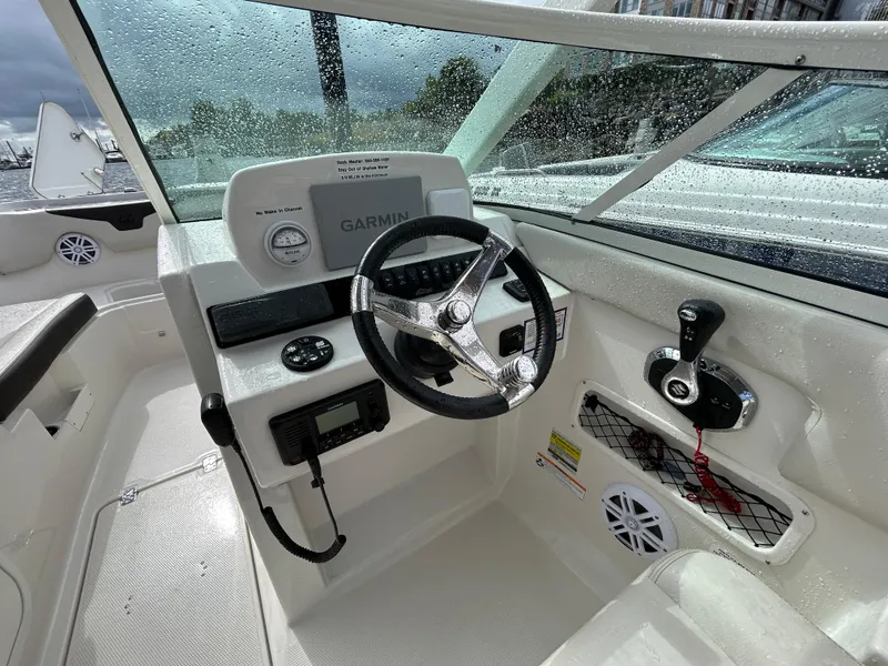 Slide: The Image of 2024 Sailfish 226 DC boat cockpit with steering wheel and Garmin navigation system. - 30
