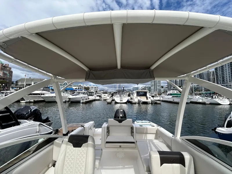 Slide: The Image of 2024 Sailfish 226 DC boat interior with marina view, featuring modern seating and canopy. - 33