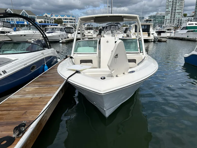 Slide: The Image of 2024 Sailfish 226 DC boat docked in a marina with other vessels. - 4