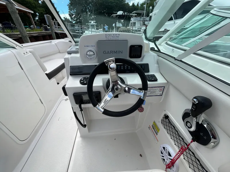 Slide: The Image of 2024 Sailfish 226 DC boat cockpit with Garmin navigation system and steering wheel. - 9