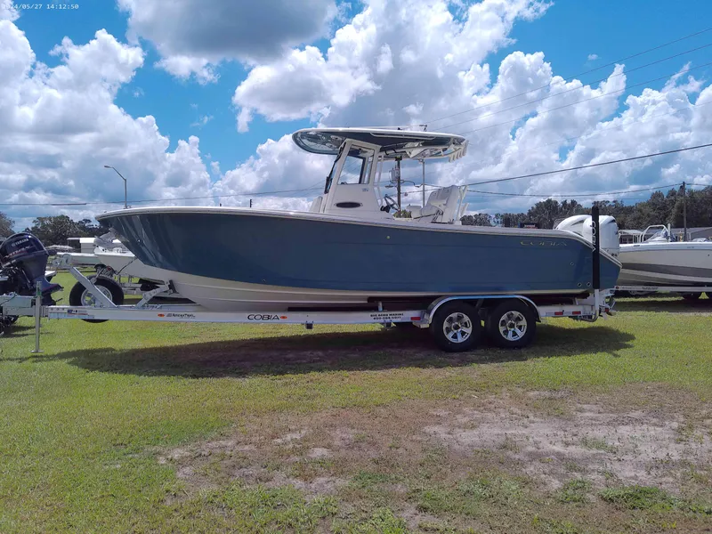 Slide: The Image of 2025 Cobia 265 Center Console boat on trailer under cloudy sky. - 1