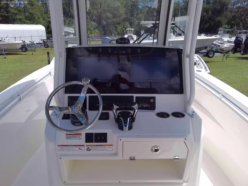 Slide: The Image of 2025 Cobia 265 Center Console boat dashboard with steering wheel and controls. - 4