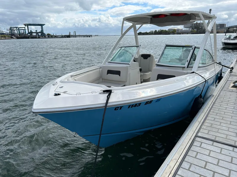 Slide: The Image of 2024 Sailfish 226 DC boat docked on a calm waterfront. - 0