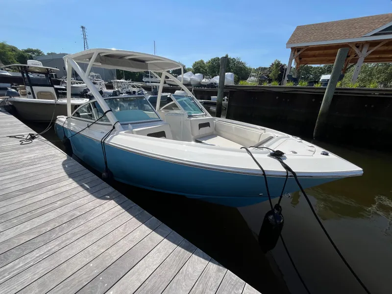 Slide: The Image of 2024 Sailfish 226 DC boat docked, featuring sleek design and blue hull. - 1