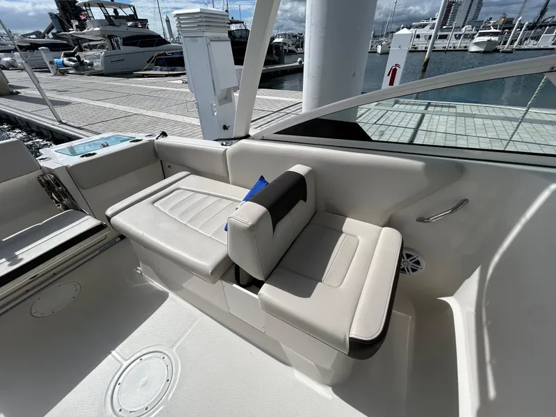 Slide: The Image of 2024 Sailfish 226 DC boat interior with beige seating at marina. - 12