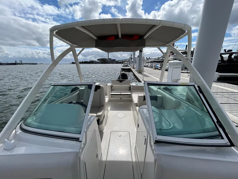 Slide: The Image of 2024 Sailfish 226 DC boat docked, featuring open deck and dual consoles under a cloudy sky. - 16