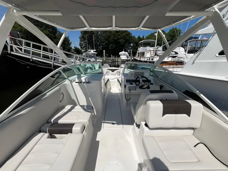 Slide: The Image of 2024 Sailfish 226 DC boat interior with seating and steering wheel, docked at marina. - 18