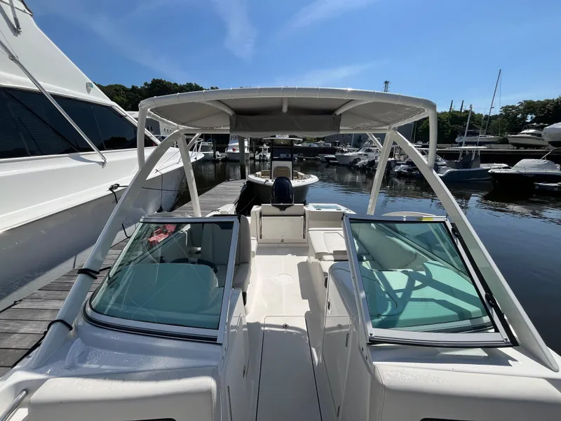 Slide: The Image of 2024 Sailfish 226 DC boat docked at marina under clear blue sky. - 21