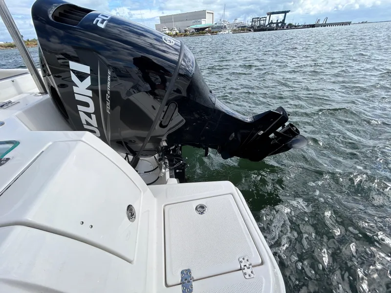Slide: The Image of 2024 Sailfish 226 DC boat with Suzuki outboard motor on water. - 23