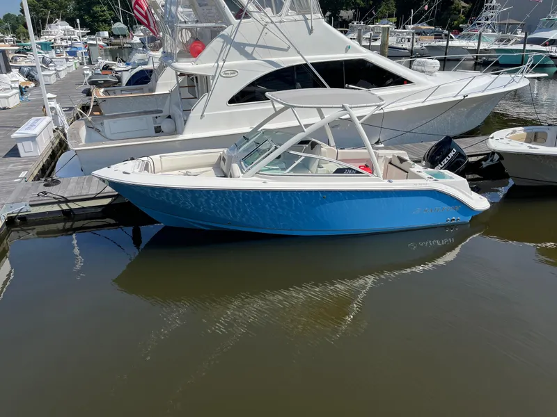 Slide: The Image of 2024 Sailfish 226 DC boat docked in a marina, featuring a sleek blue and white design. - 3