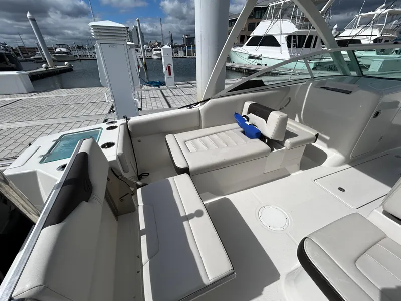 Slide: The Image of 2024 Sailfish 226 DC boat interior with white seating at marina dock. - 8