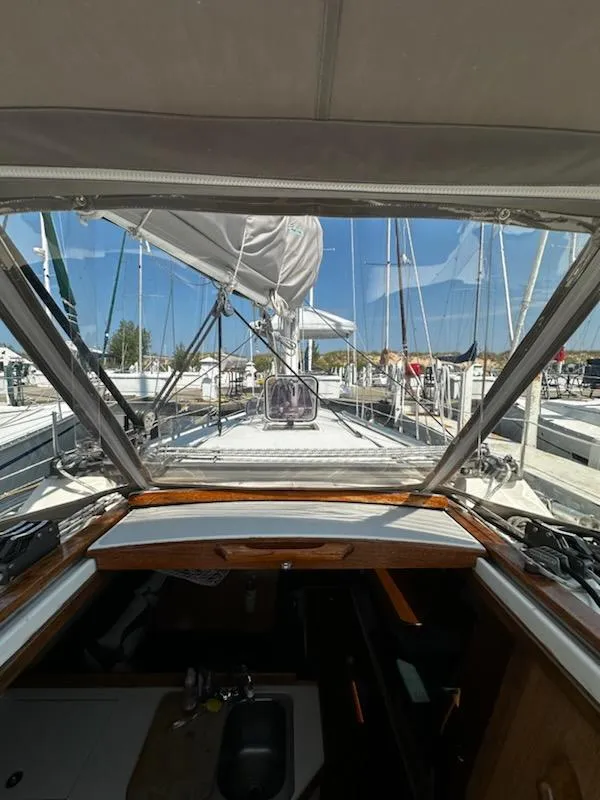Slide: The Image of 1994 Catalina 36 sailboat cockpit view with sails and marina background. - 14