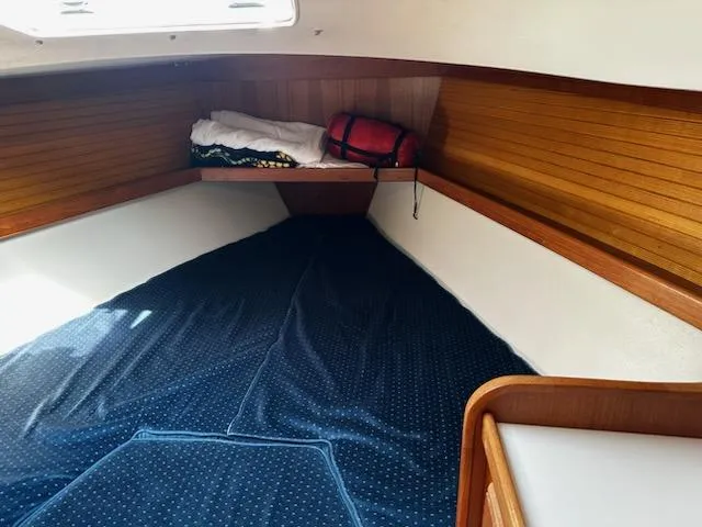 Slide: The Image of Interior cabin of a 1994 Catalina 36 sailboat with wooden paneling and bedding. - 17