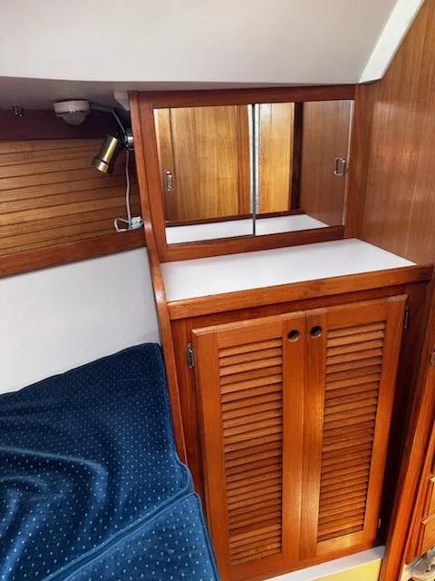 Slide: The Image of Interior of 1994 Catalina 36 sailboat with wooden cabinetry and blue bedding. - 20