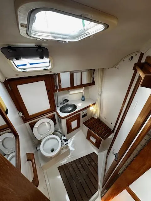 Slide: The Image of 1994 Catalina 36 yacht bathroom with wooden accents, sink, and toilet. - 21