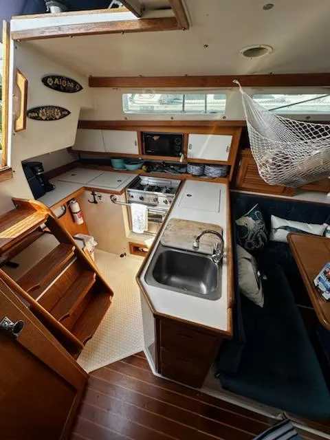Slide: The Image of 1994 Catalina 36 yacht interior with kitchen, dining area, and wooden finishes. - 22
