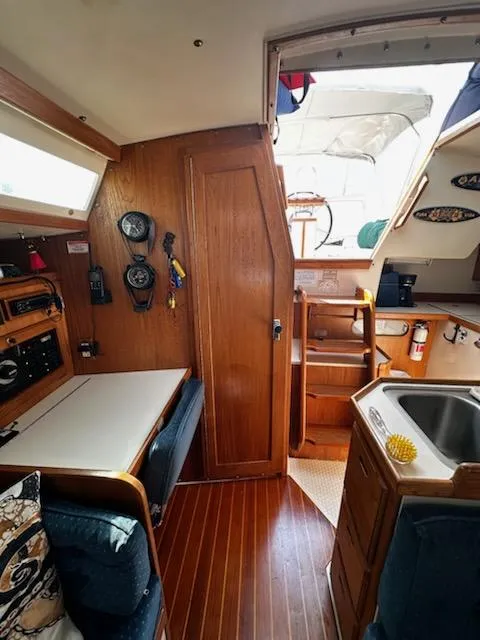 Slide: The Image of Interior of a 1994 Catalina 36 sailboat with wood paneling and compact kitchen area. - 27