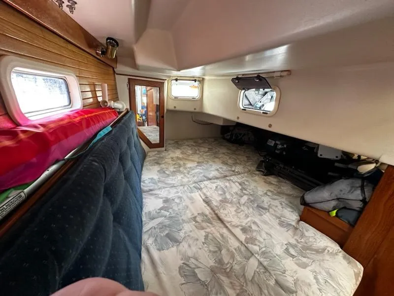 Slide: The Image of Cozy interior cabin of a 1994 Catalina 36 sailboat with floral bedding and wooden accents. - 28