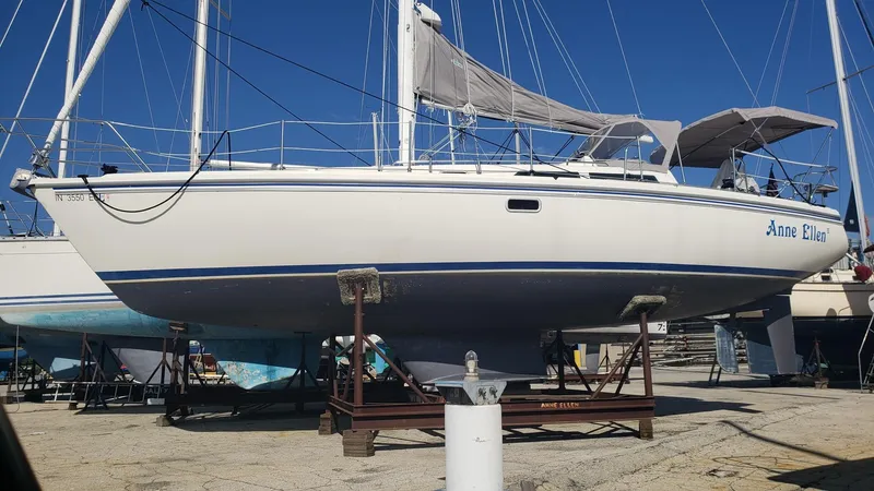 Slide: The Image of 1994 Catalina 36 sailboat on dry dock, white hull, blue stripe, named "Anne Ellen." - 7