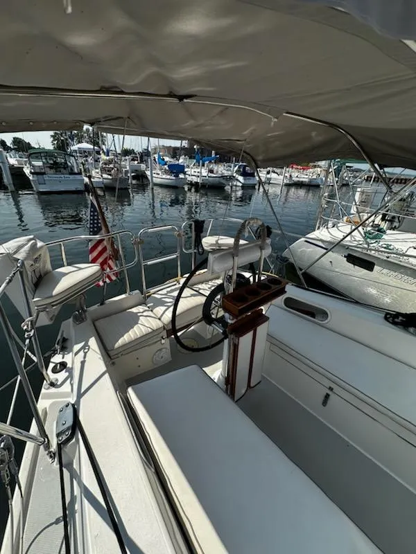 Slide: The Image of 1994 Catalina 36 sailboat cockpit with marina view, featuring steering wheel and seating. - 9