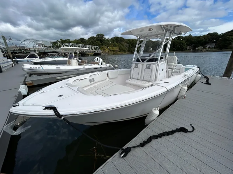 Slide: The Image of 2025 Sea Fox 248 Commander boat docked on a calm lake under cloudy skies. - 4