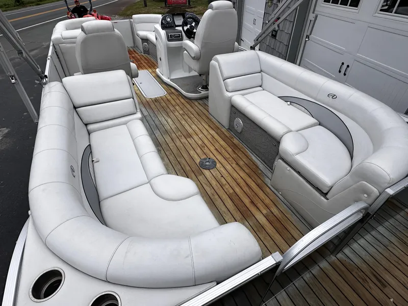 Slide: The Image of 2014 Avalon Catalina Quad Lounge boat with white seating and wooden deck. - 11