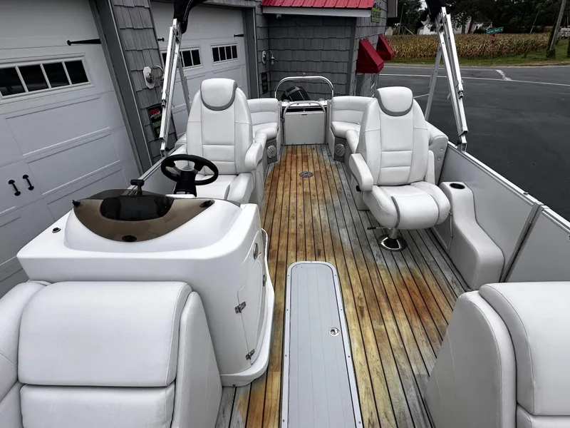 Slide: The Image of 2014 Avalon Catalina Quad Lounge boat interior with white seating and wood flooring. - 12