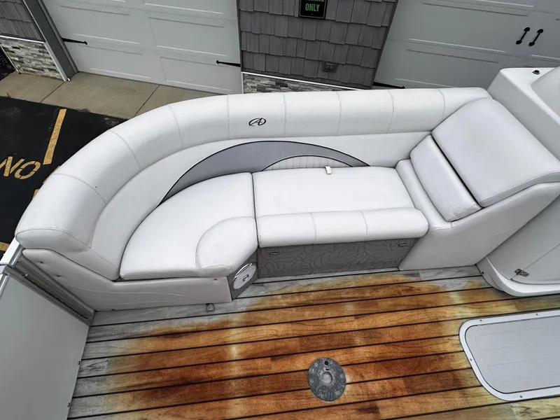 Slide: The Image of 2014 Avalon Catalina Quad Lounge boat interior with white seating and wooden deck. - 13