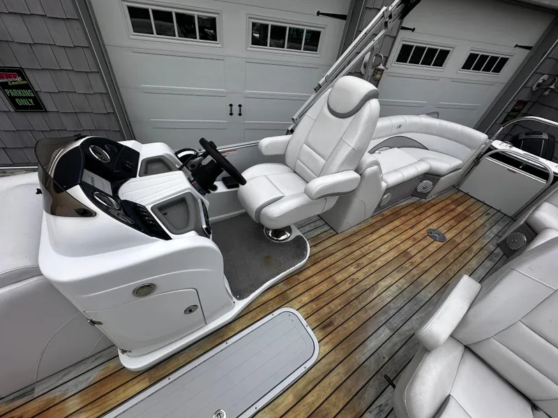 Slide: The Image of 2014 Avalon Catalina Quad Lounge boat interior with white seating and wood flooring. - 15