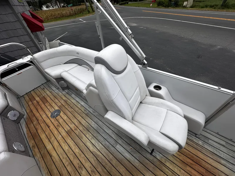 Slide: The Image of 2014 Avalon Catalina Quad Lounge boat interior with white seating and wooden deck. - 16