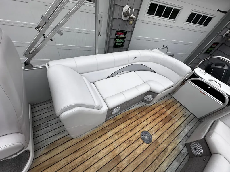 Slide: The Image of 2014 Avalon Catalina Quad Lounge boat interior with white seating and wooden deck. - 18