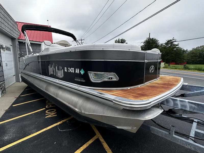 Slide: The Image of 2014 Avalon Catalina Quad Lounge 24' Triple Toon pontoon boat on trailer, parked outdoors. - 6