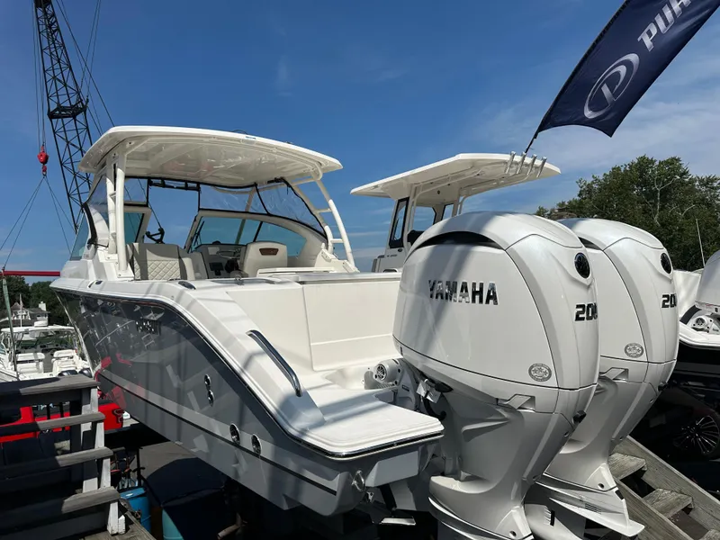 Slide: The Image of 2025 Pursuit DC 266 Dual Console boat with twin Yamaha engines displayed outdoors. - 2