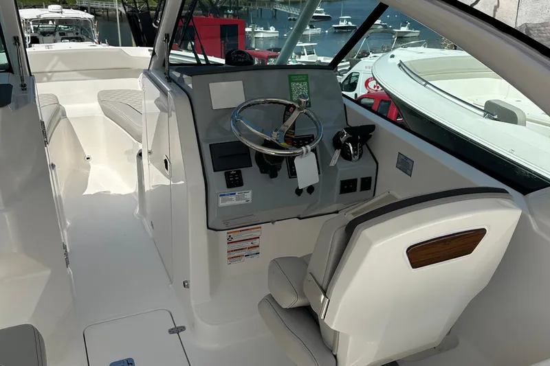 Slide: The Image of 2025 Pursuit DC 266 Dual Console boat interior with steering wheel and seating. - 7