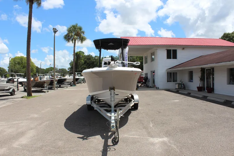Slide: The Image of 2024 Clearwater 2200 WI Center Console boat on trailer, parked outside dealership. - 2