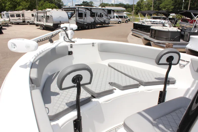 Slide: The Image of 2024 Clearwater 2200 WI Center Console boat with cushioned seating in a marina setting. - 20