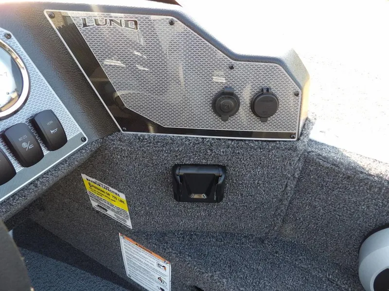 Slide: The Image of 2025 Lund 1775 Adventure SS boat dashboard with controls and textured panel. - 11