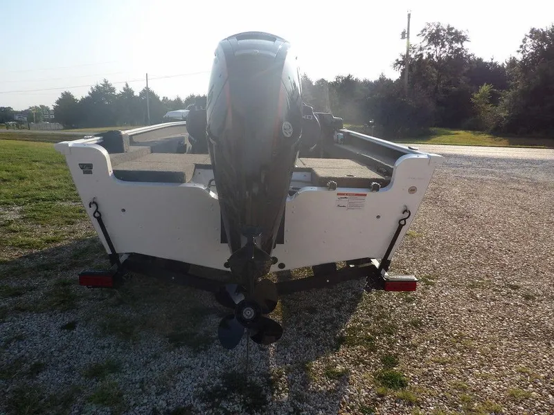 Slide: The Image of 2025 Lund 1775 Adventure SS boat, rear view with outboard motor, parked on gravel. - 5