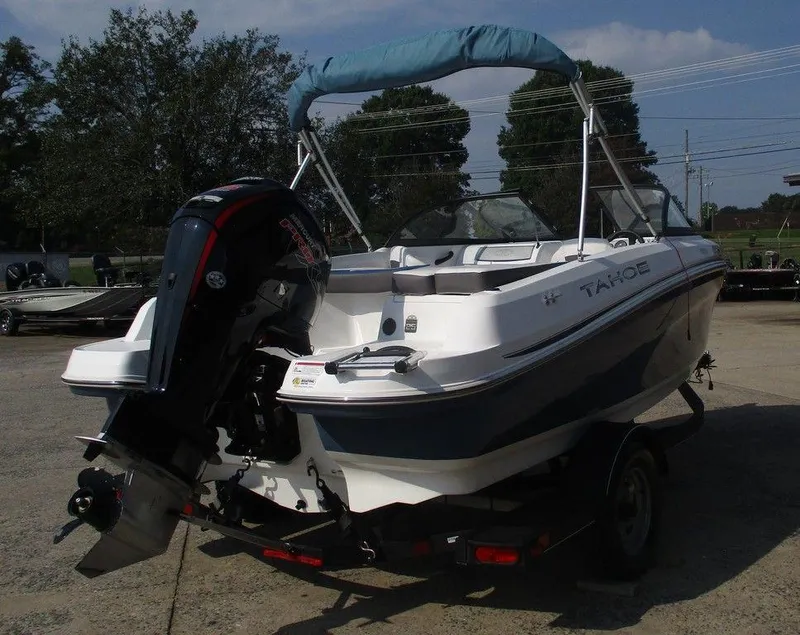 Slide: The Image of 2023 Tahoe 185 S boat with outboard motor on trailer, parked outdoors. - 3