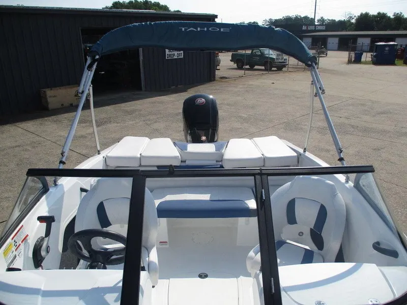 Slide: The Image of 2023 Tahoe 185 S boat with canopy and seating, parked outdoors. - 4