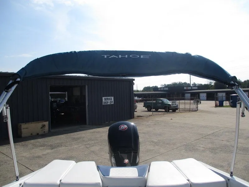 Slide: The Image of 2023 Tahoe 185 S boat with canopy, parked near service area. - 8