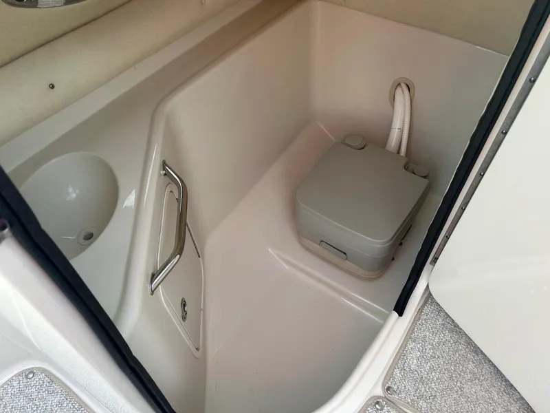Slide: The Image of 2007 Sea Ray 240 Sundeck interior with portable toilet and storage compartment. - 12