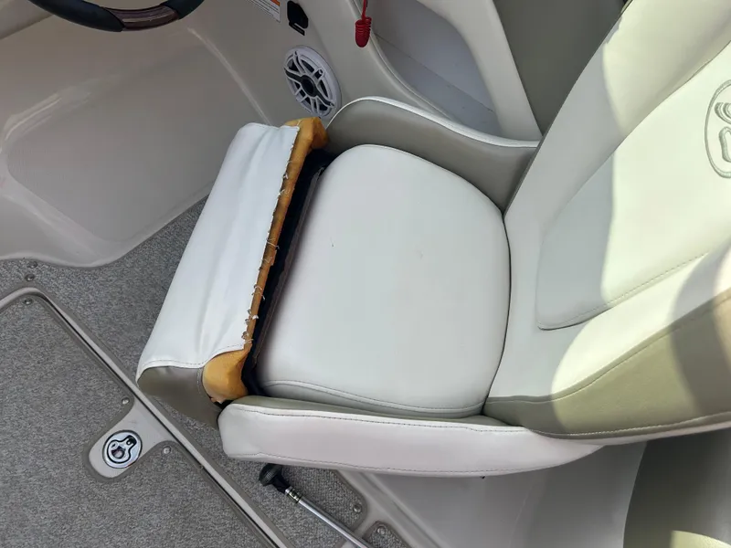 Slide: The Image of Captain's seat on 2007 Sea Ray 240 Sundeck boat, featuring white upholstery and speaker. - 18