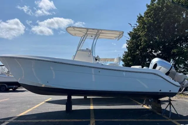 Slide: The Image of 2020 Cobia 237 Center Console boat on display in a parking lot. - 0